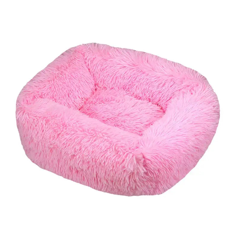 Fluffy pink pet bed with raised sides and a cushioned center.