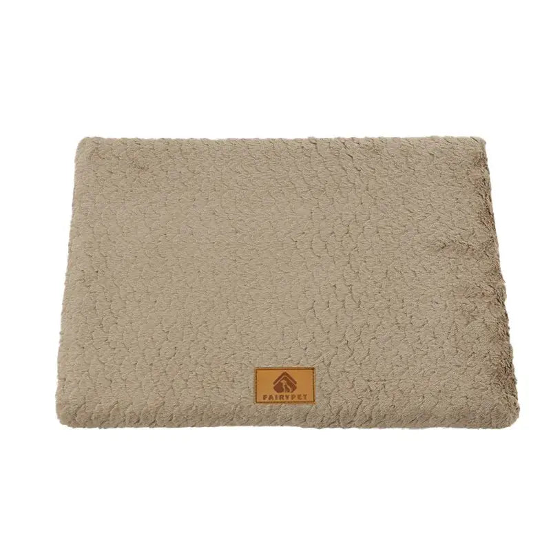 Beige plush pet bed with a brown leather tag.