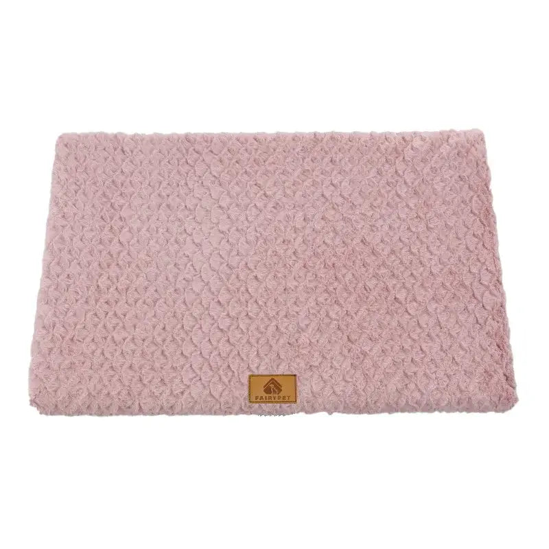 Soft pink textured pet bed or mat with a small brown label.