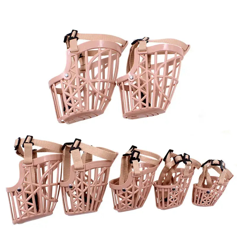 Dog muzzles in various sizes made of pink plastic with a basket-like design.