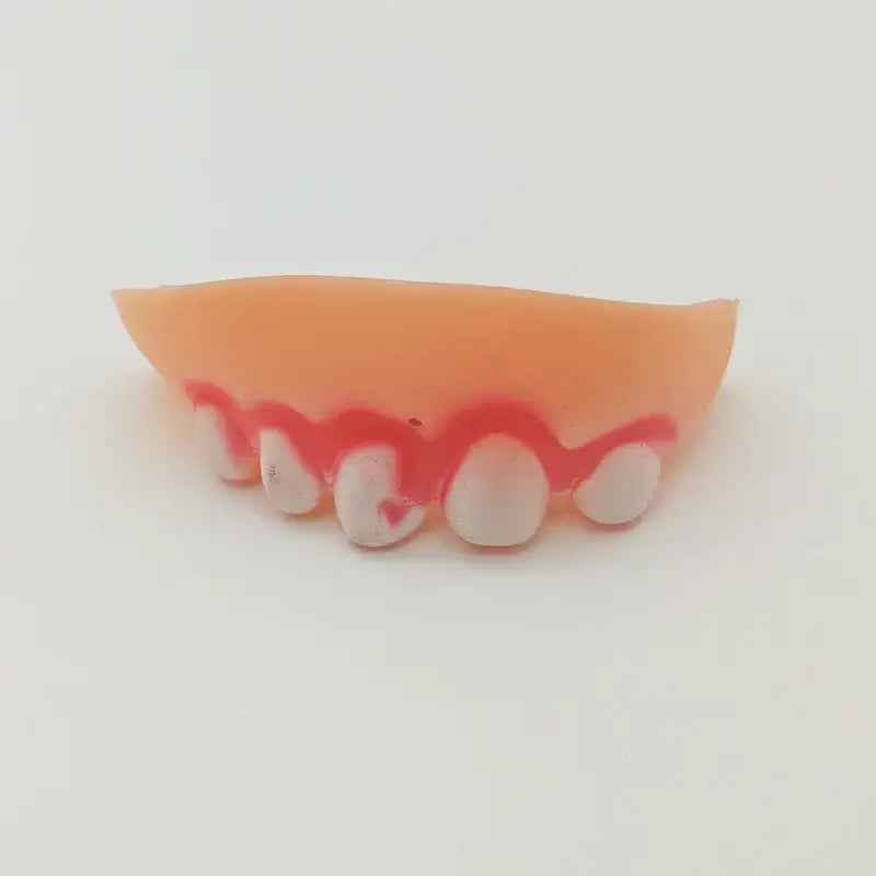 Set of fake teeth or dentures with pink gums and white teeth.