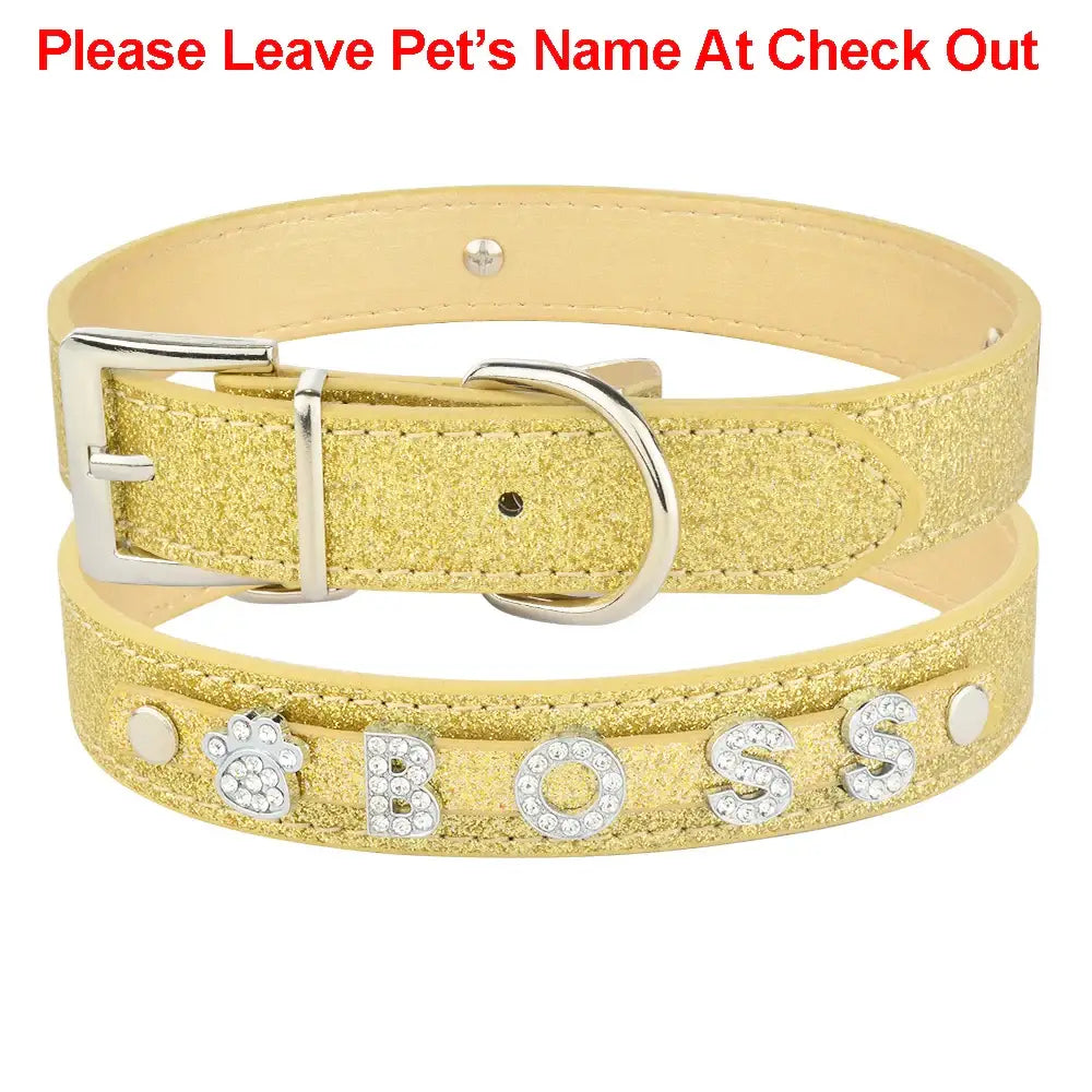 Glittery gold pet collar with rhinestone letters spelling ’BOSS’.