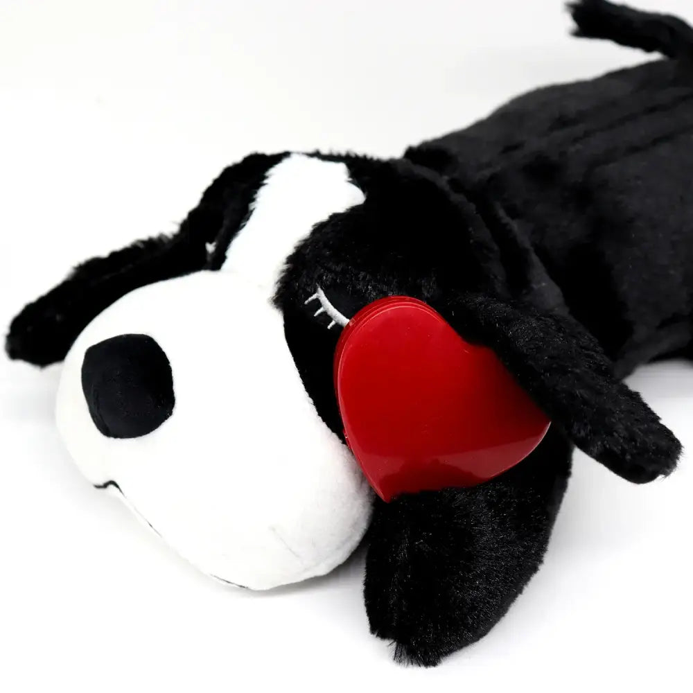 Plush toy dog with black and white fur and a red heart-shaped patch.