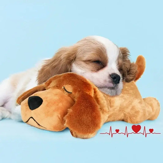 Sleeping puppy resting on a plush dog toy with a heartbeat line beneath.