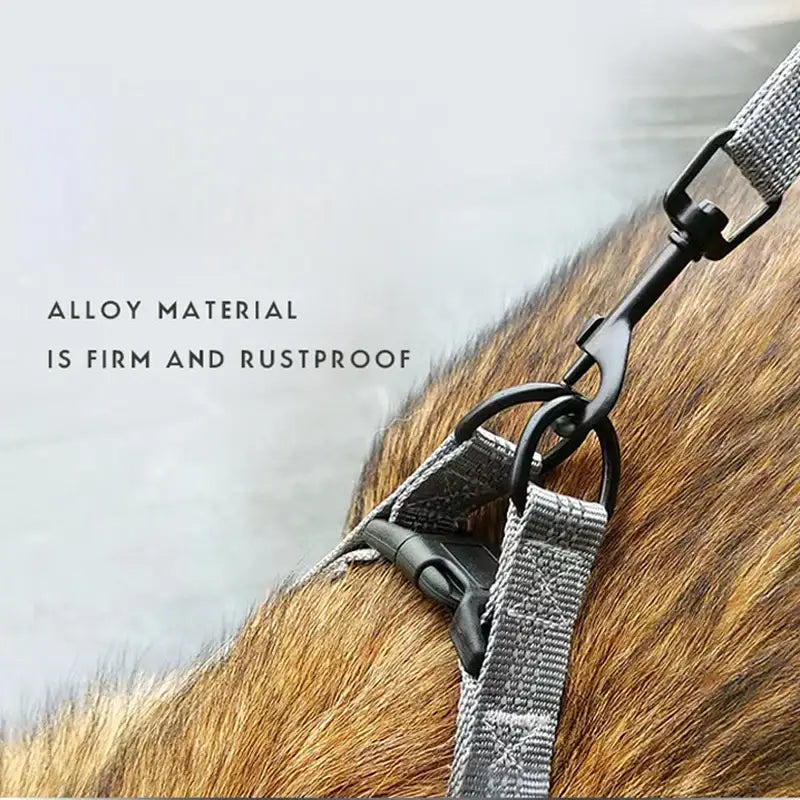 Metal clip or fastener attached to a gray fabric strap, shown against animal fur.