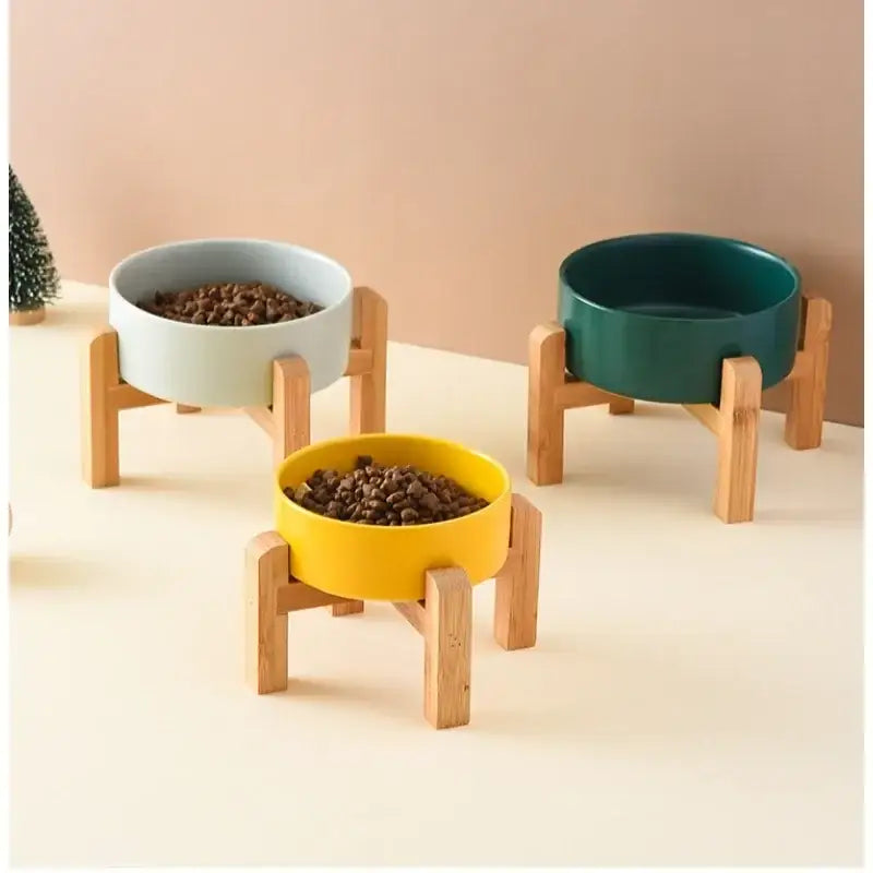 Set of three colorful raised pet food bowls with wooden stands.