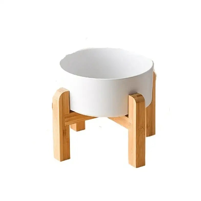 White ceramic bowl on a wooden stand with four legs.