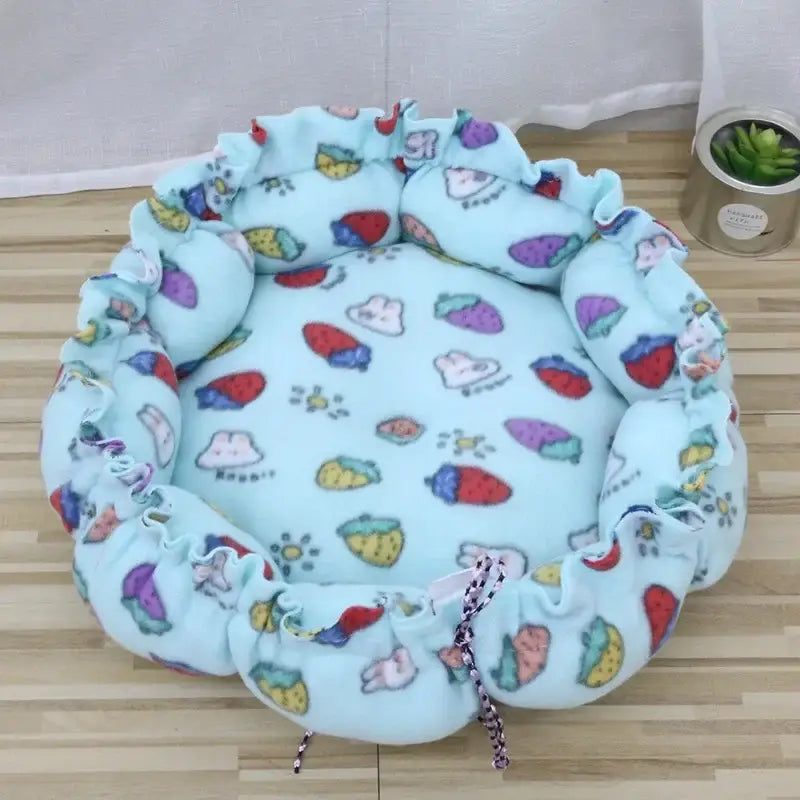 Circular pet bed with a colorful fruit and animal print pattern.