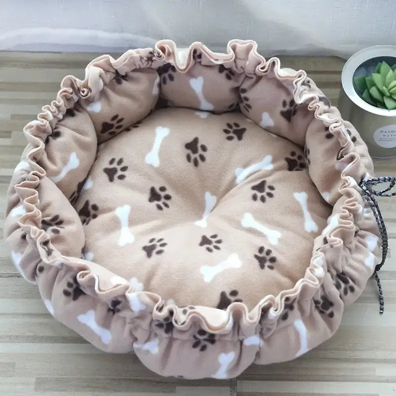 Circular pet bed with a ruffled edge and paw print pattern.