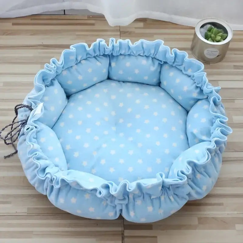 Light blue circular pet bed with white polka dots and ruffled edges.