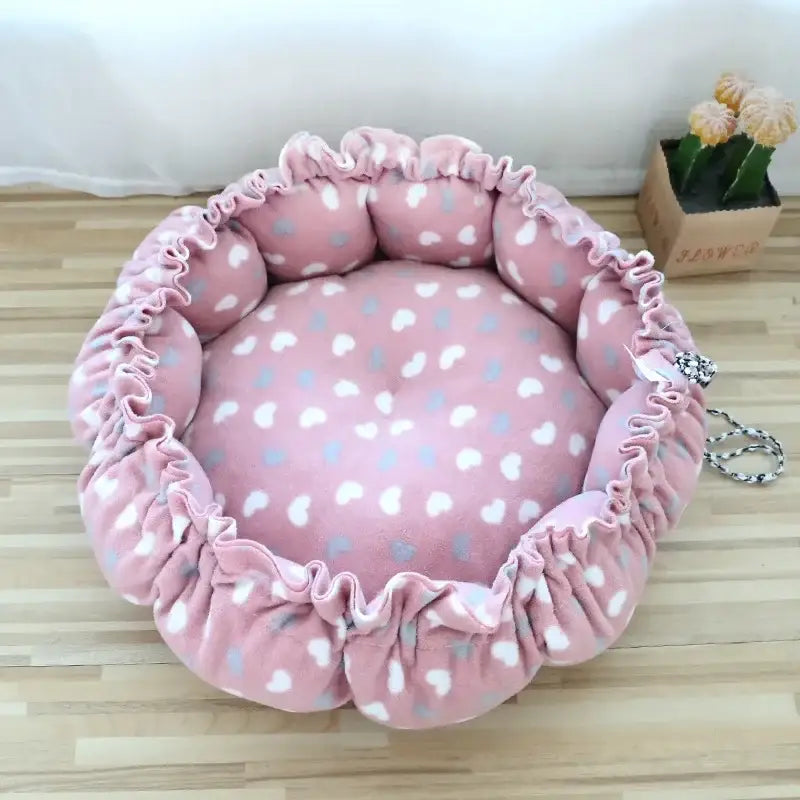 Pink polka-dotted circular pet bed with gathered edges.