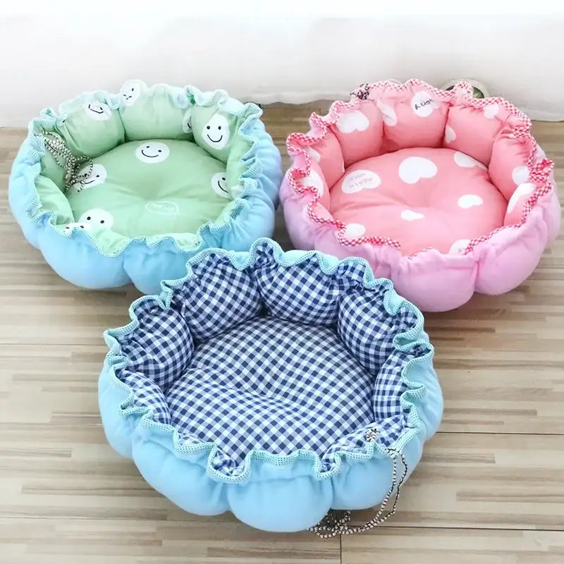 Three colorful, plush pet beds shaped like flowers.