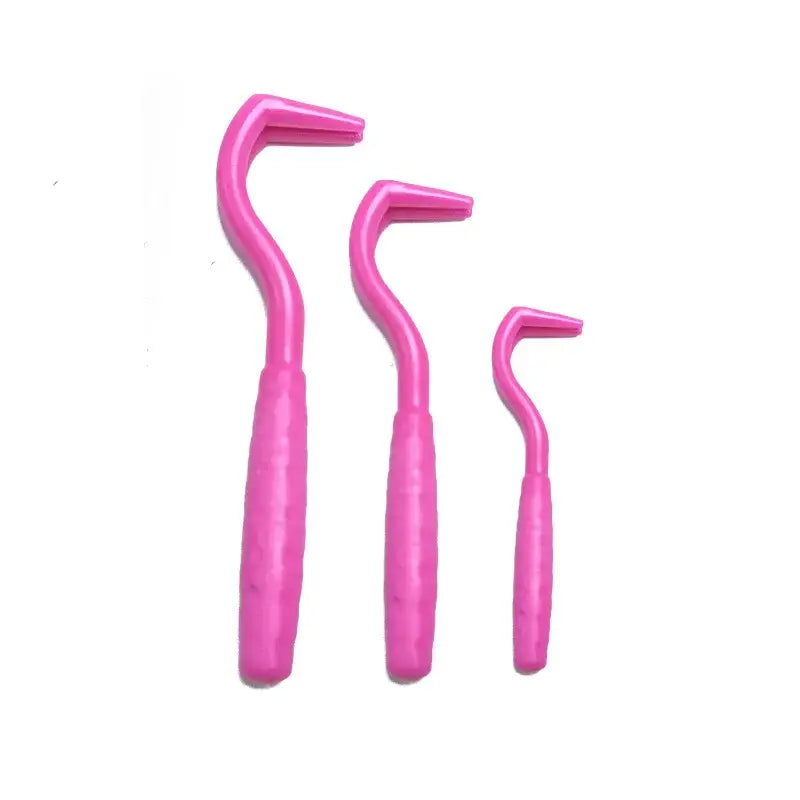 Set of three pink interdental brushes in different sizes.