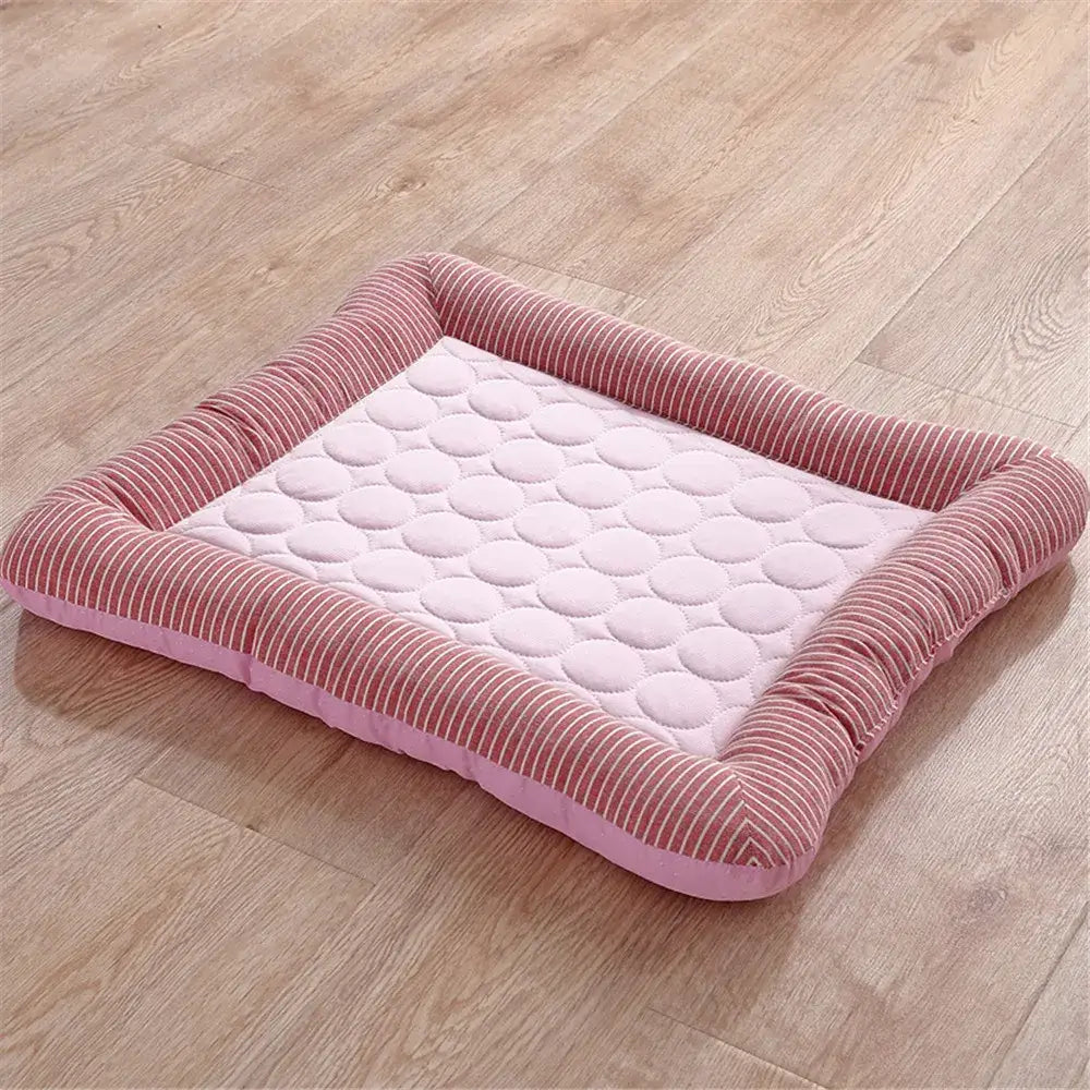 Pink rectangular pet bed with a corduroy border and quilted center cushion.