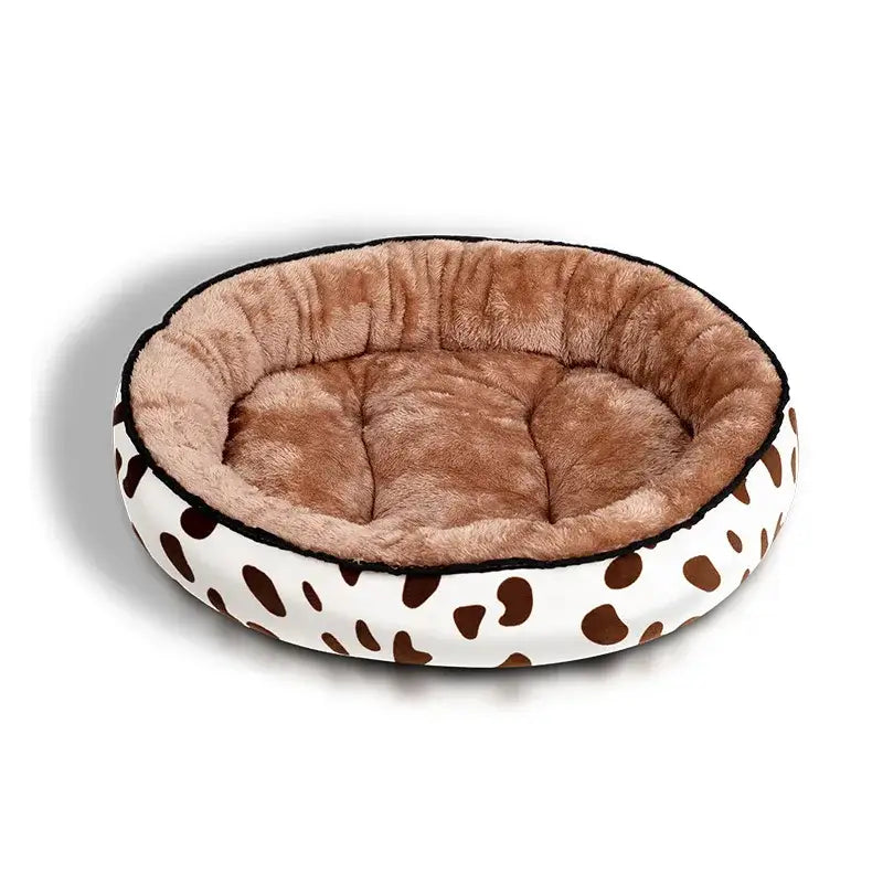 Circular pet bed with a brown interior and white exterior featuring dark spots.