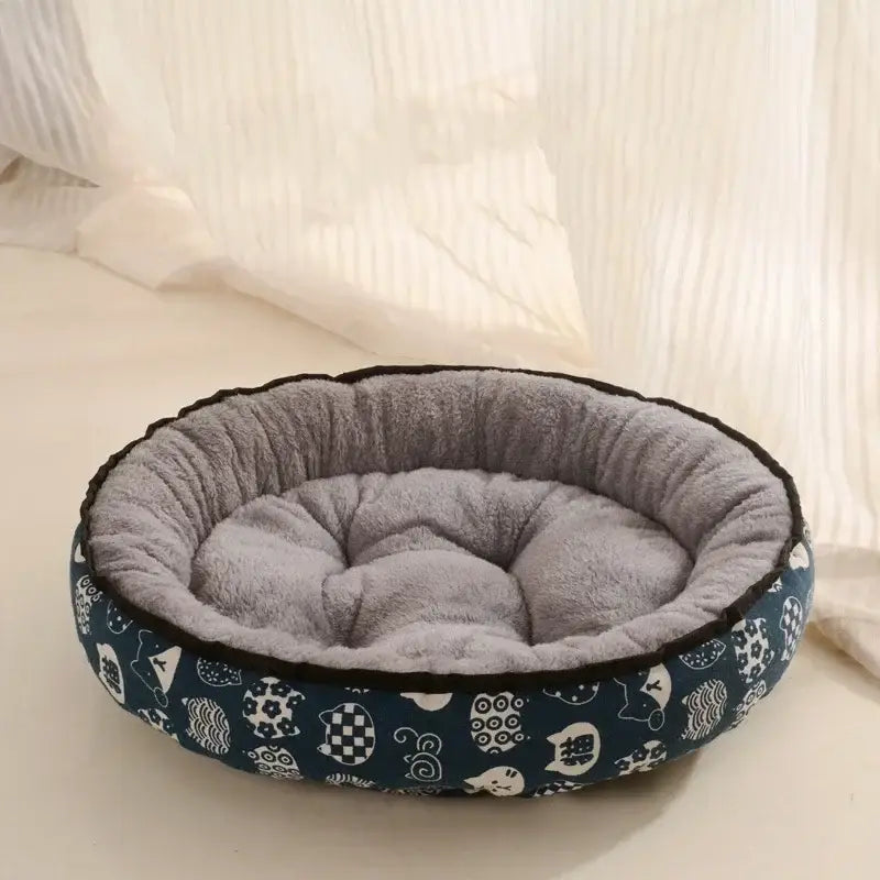 Circular pet bed with a navy patterned exterior and plush gray interior cushioning.