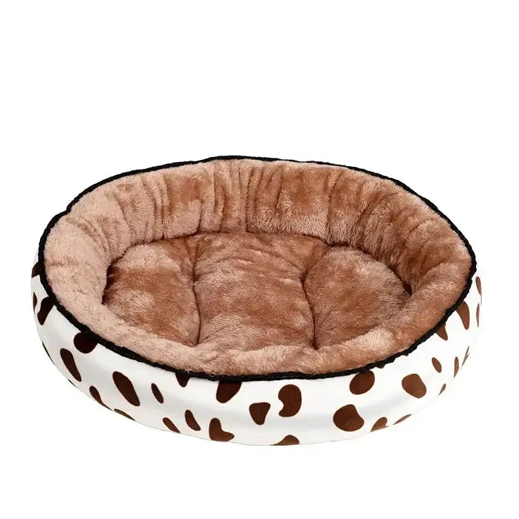 Plush round pet bed with a cow-print exterior and soft brown interior cushioning.