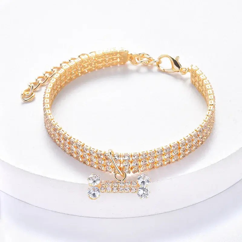 Glittery gold pet collar with a rhinestone-encrusted bone-shaped charm.