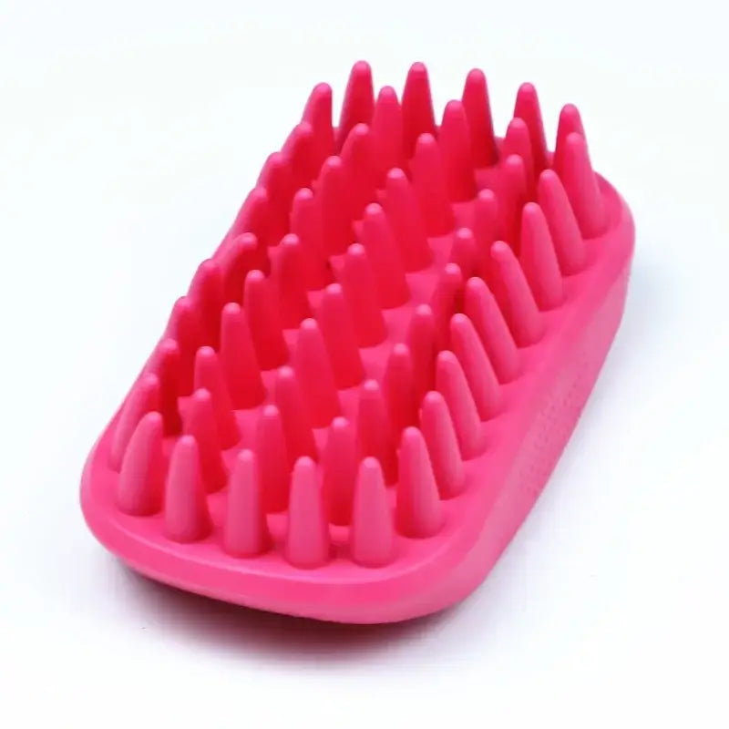 Pink plastic brush with numerous soft, flexible bristles arranged in rows.