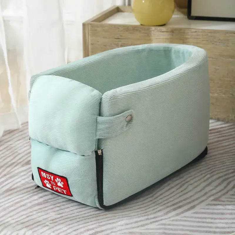 Mint green fabric pet carrier with a zippered opening and a red tag.