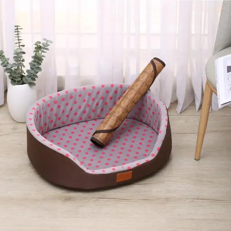 Oval pet bed with pink polka dot lining and a brown exterior.