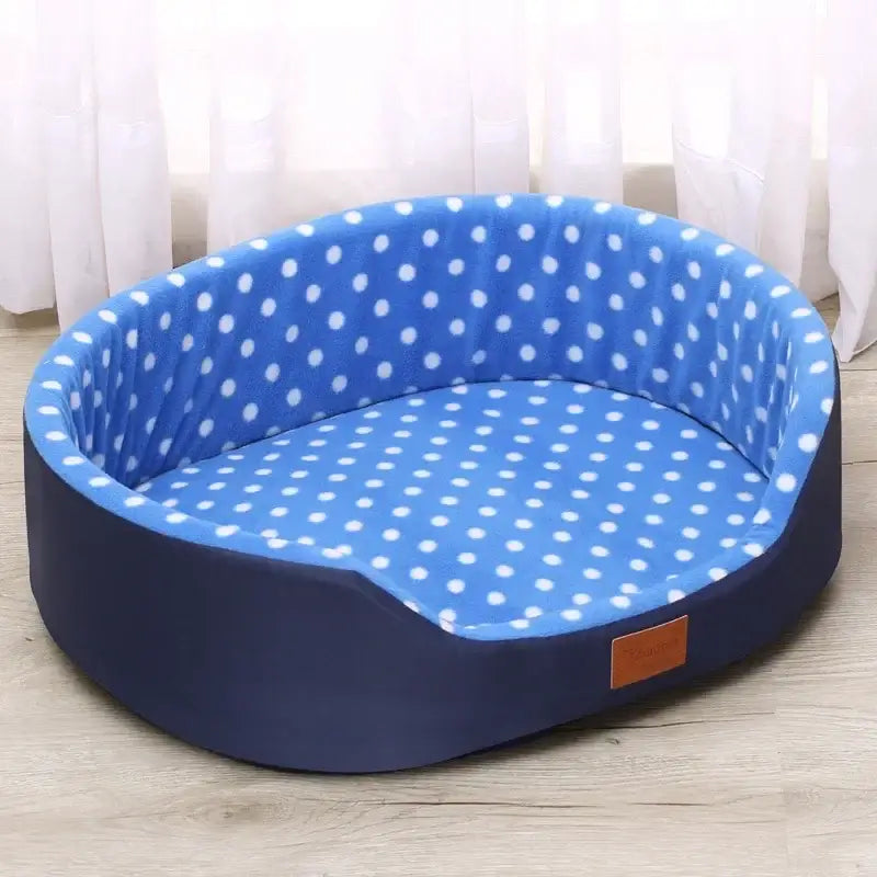 Oval-shaped pet bed with blue polka dot interior and navy blue exterior.