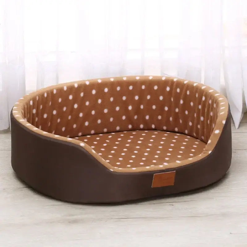 Oval-shaped pet bed with brown polka dot pattern and dark brown exterior.