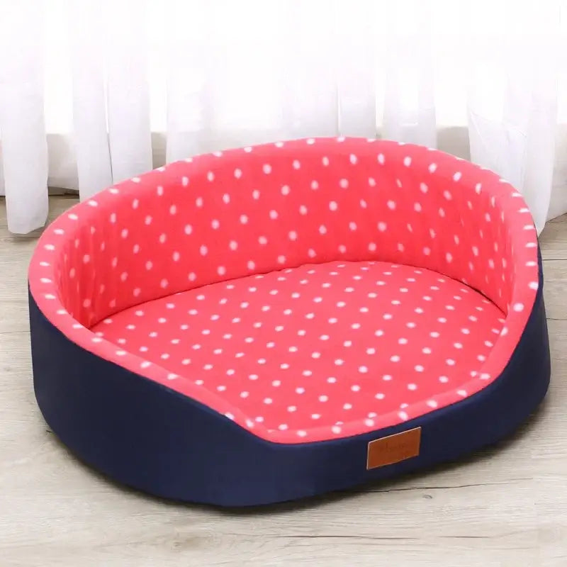 Oval-shaped pet bed with pink polka dot interior and navy blue exterior.