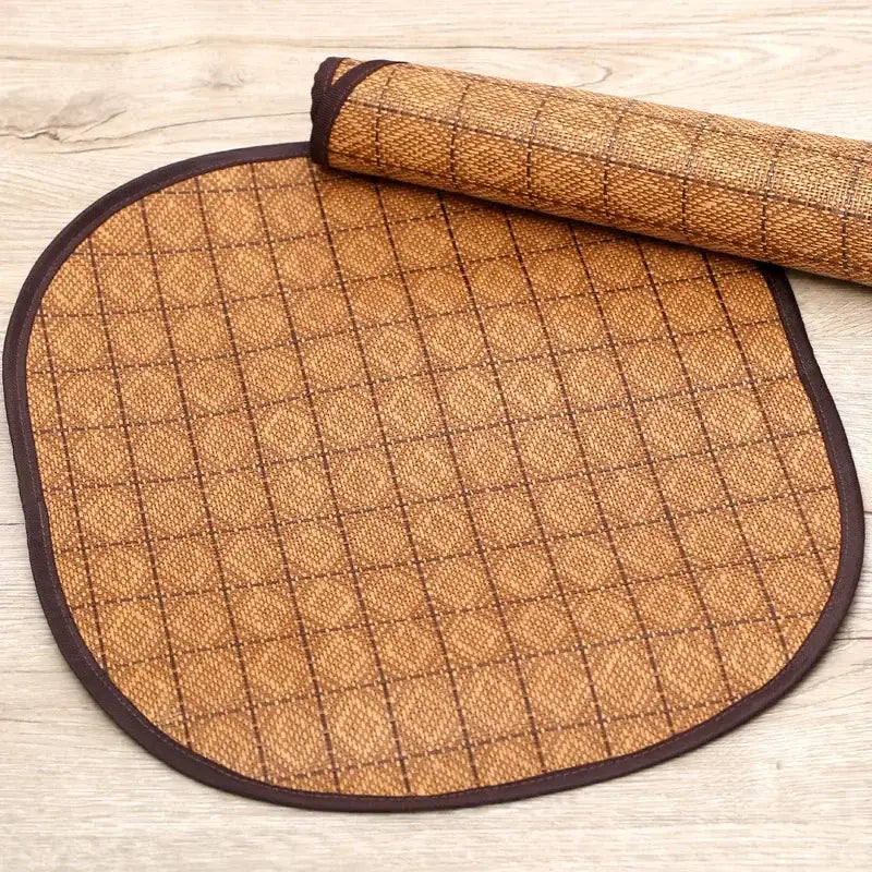 Oval-shaped woven bamboo mat with a diamond pattern and dark trim.