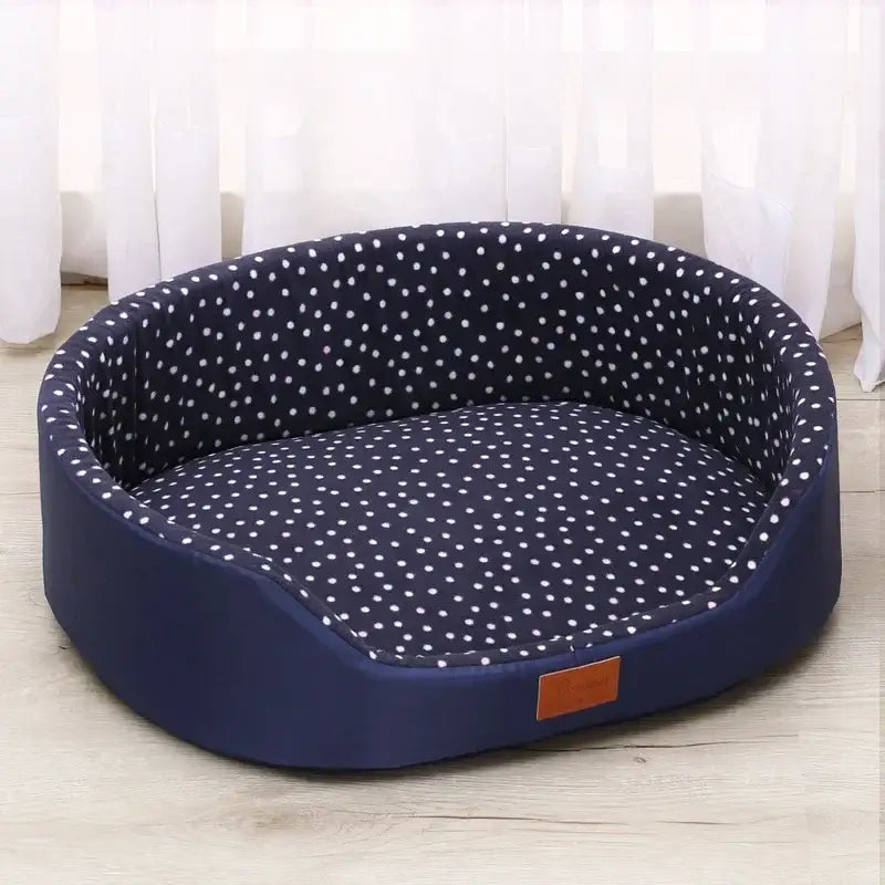 Round pet bed with navy blue exterior and white polka dot interior lining.