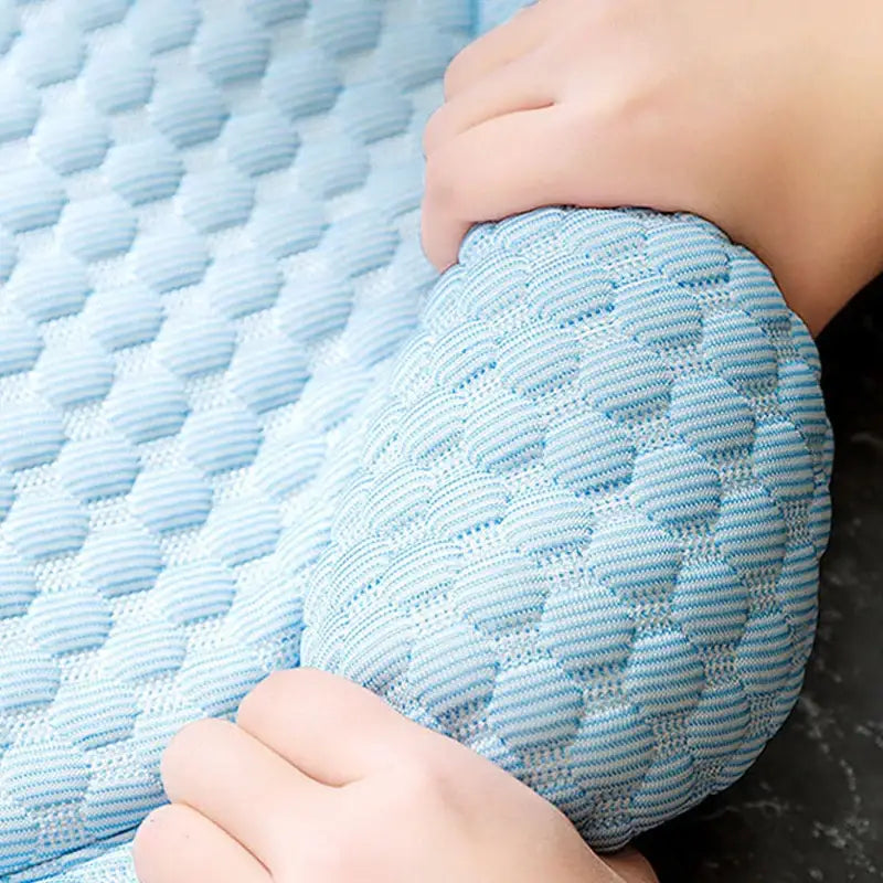 Textured light blue fabric with a honeycomb or waffle-like pattern.