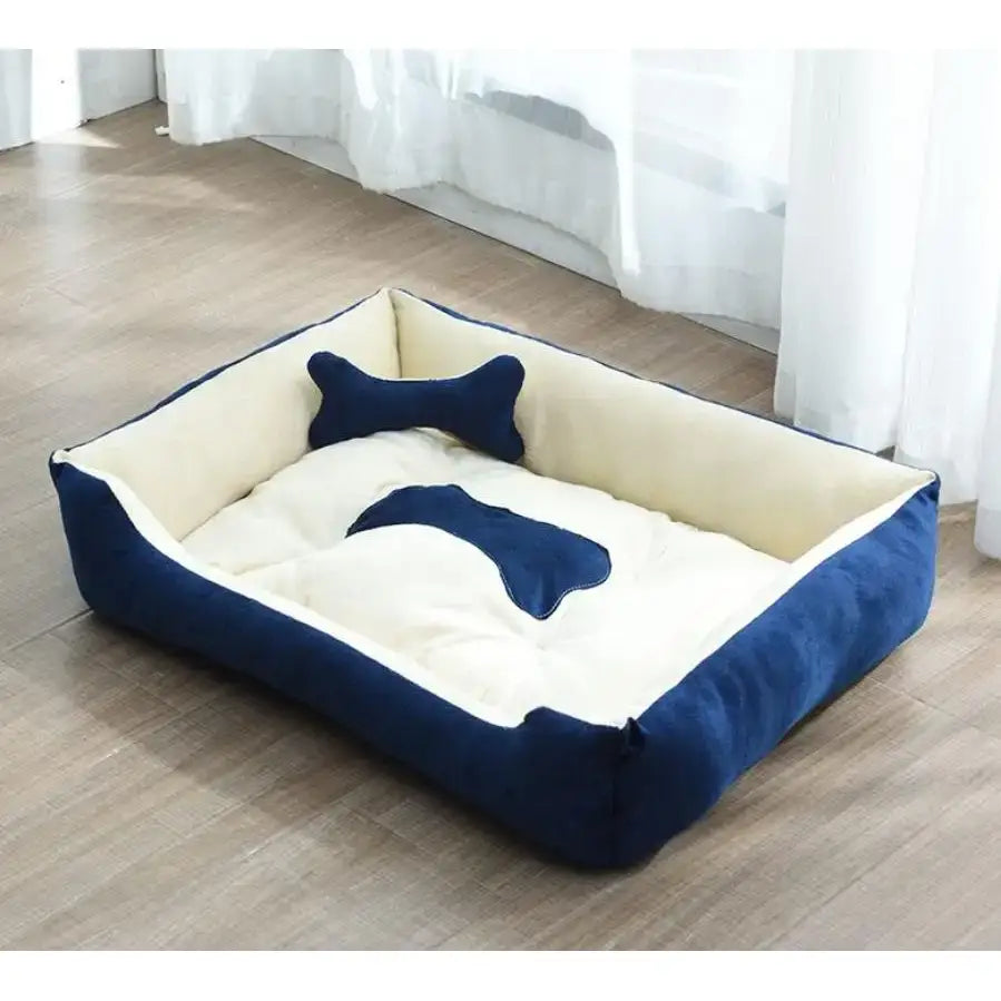 Dog bed with navy blue edges and two bone-shaped pillows.