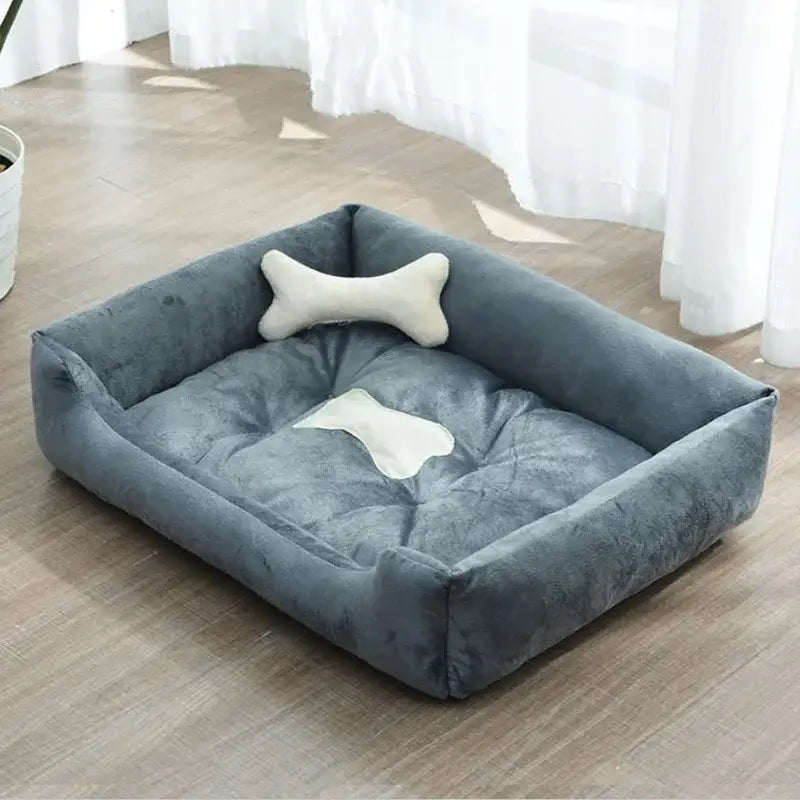 Plush gray rectangular pet bed with a bone-shaped pillow.