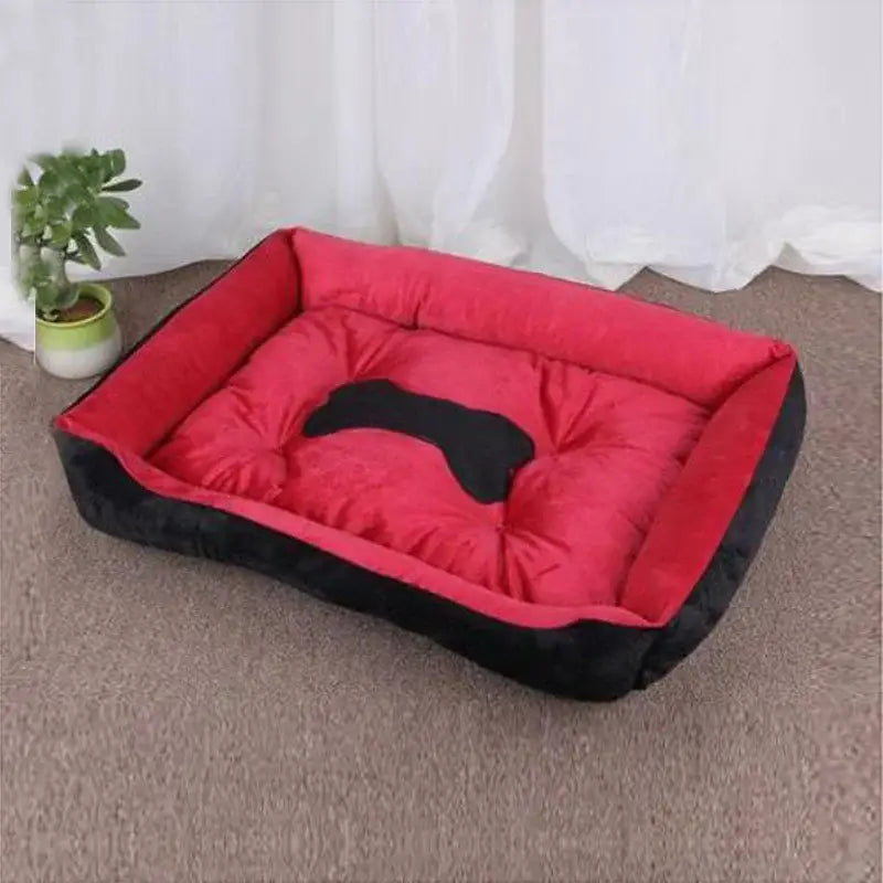 Red and black padded dog bed with a bone-shaped design on the cushion.