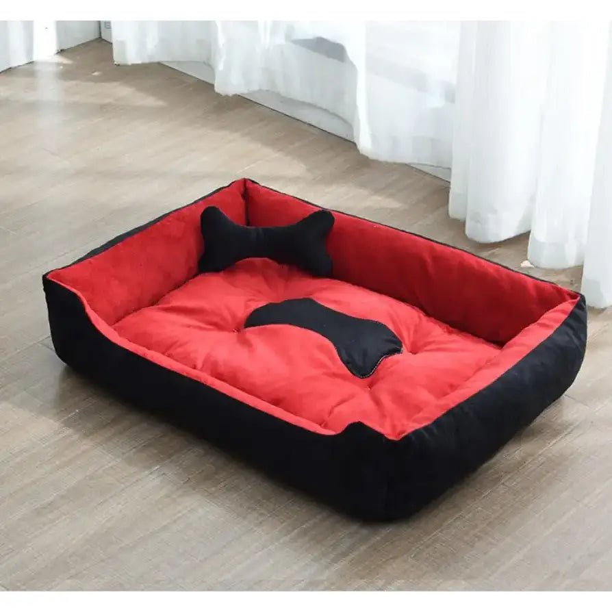 Red and black rectangular pet bed with a bone-shaped cushion.