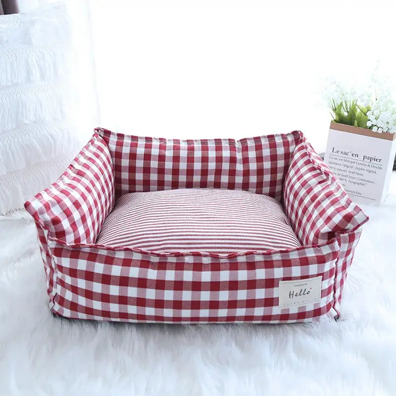 Red and white gingham patterned pet bed with striped cushion.