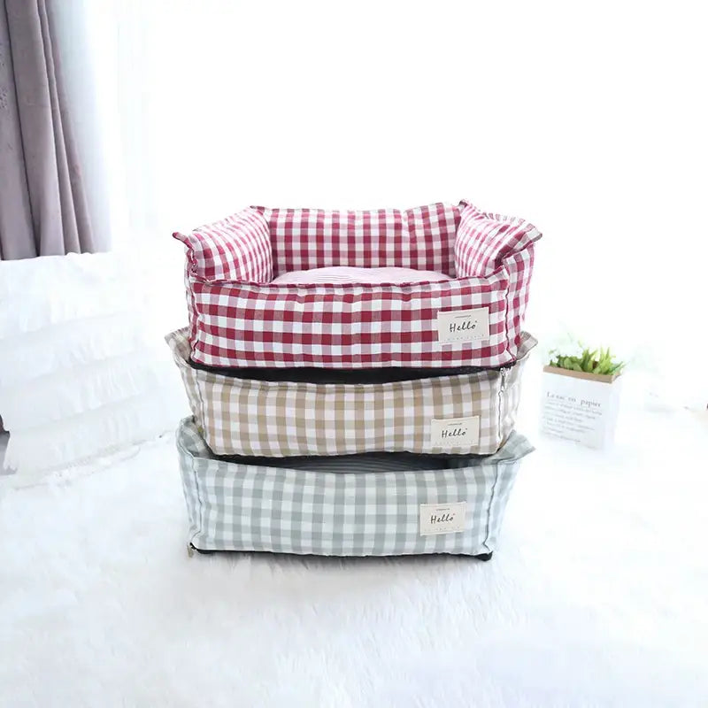 Stack of three plaid fabric pet beds in different colors.