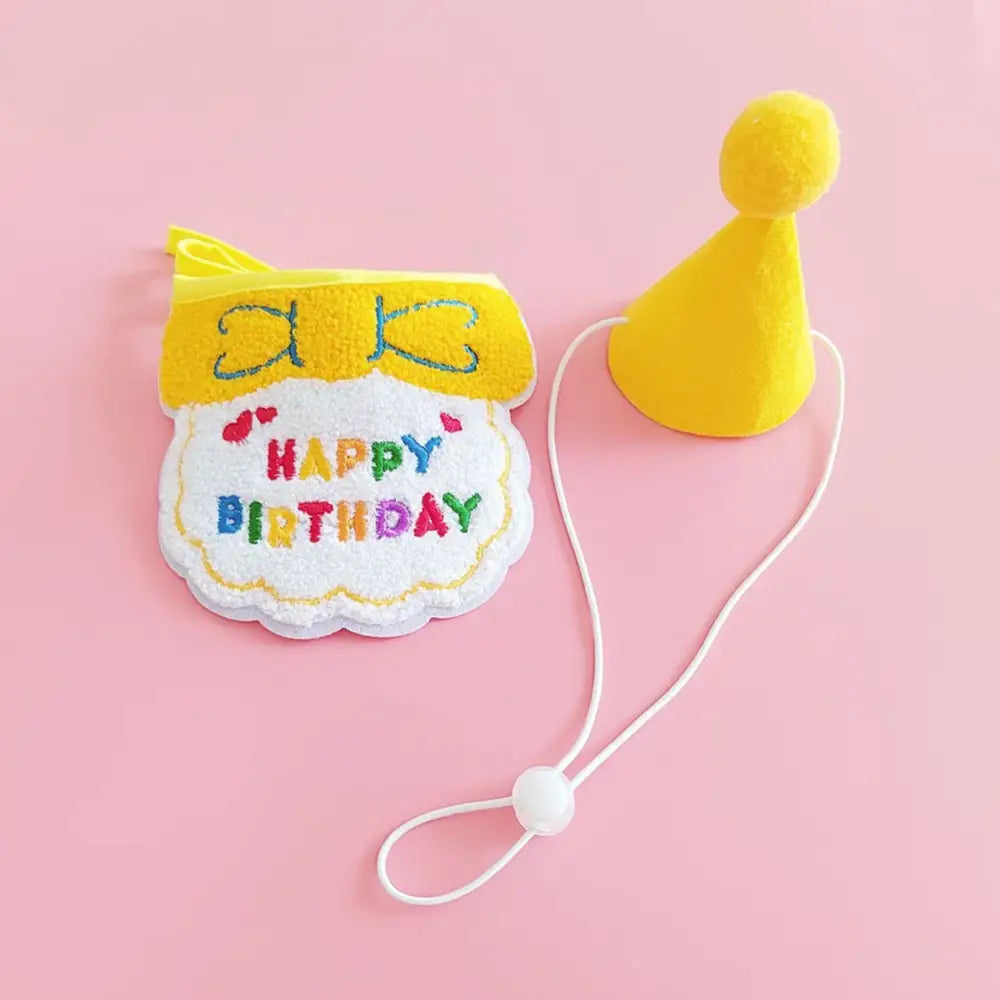 Colorful felt birthday bib with ’Happy Birthday’ text and a yellow party hat attached by string.