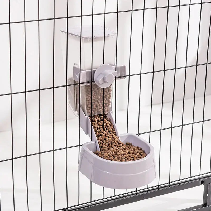 Pet food dispenser attached to a wire cage, releasing kibble into a bowl.