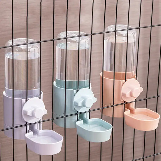 Pet water dispensers attached to a wire cage or enclosure.