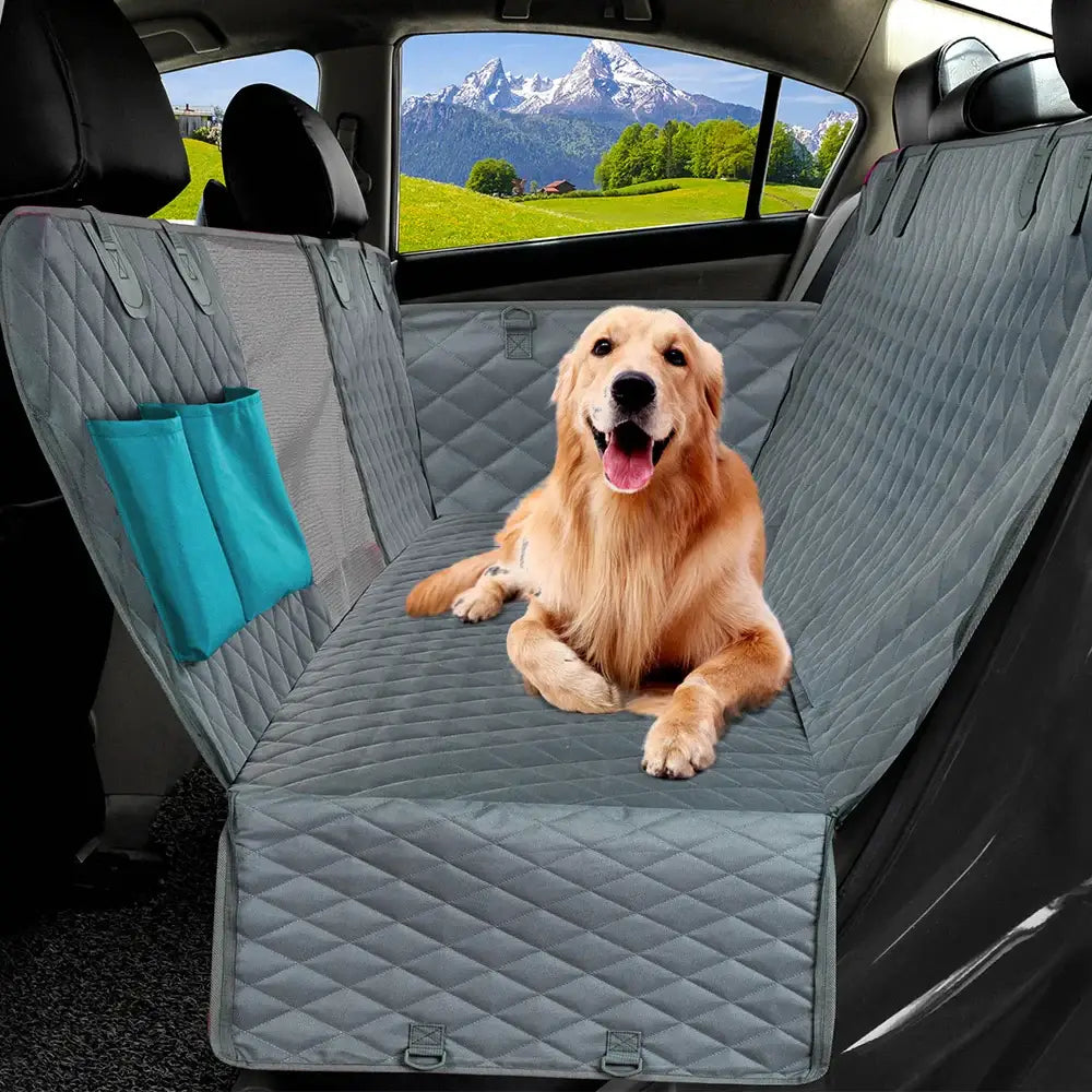 Golden Retriever sitting on a quilted car seat cover.