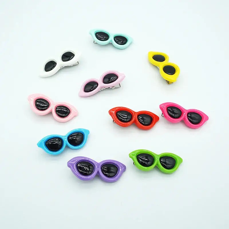 Colorful miniature sunglasses charms or decorations in various shapes and hues.