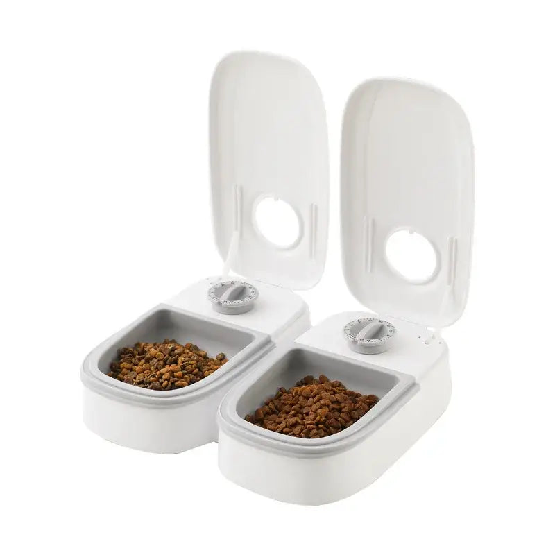 Automatic pet feeder with two compartments containing dry pet food.