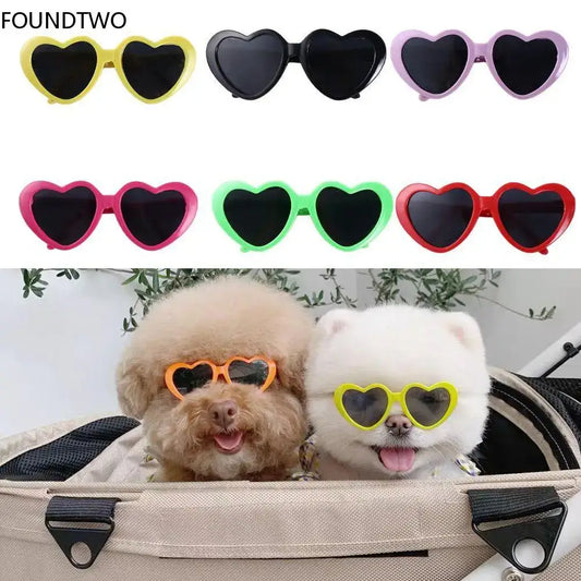 Heart-shaped sunglasses in various colors, with two dogs wearing them at the bottom of the image.