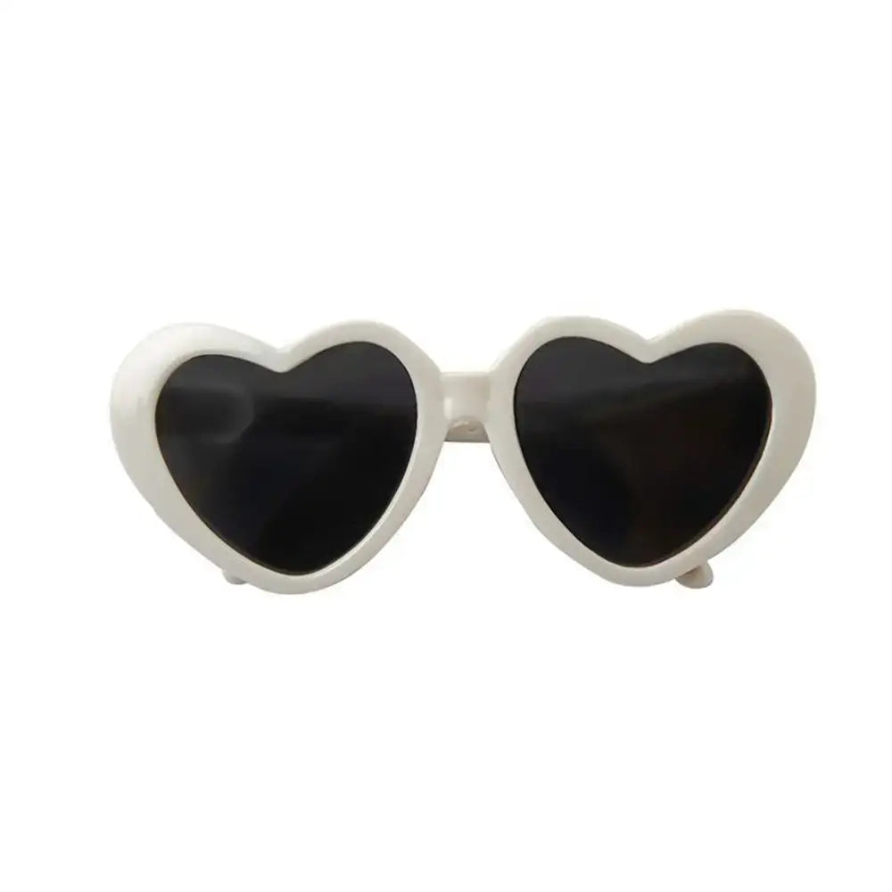 Heart-shaped sunglasses with white frames and dark lenses.