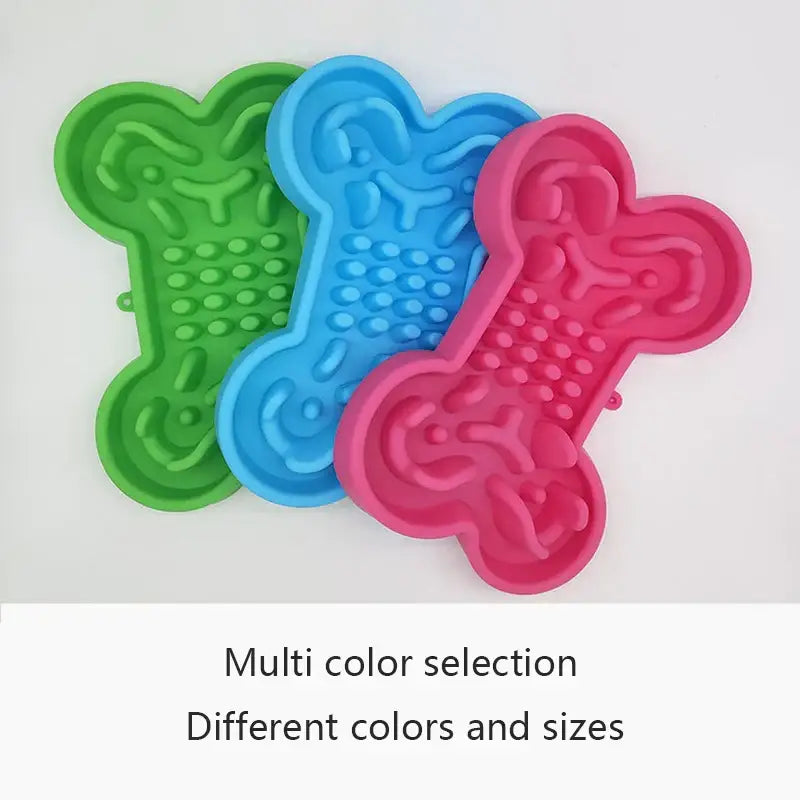 Colorful bone-shaped silicone mats or molds in green, blue, and pink.