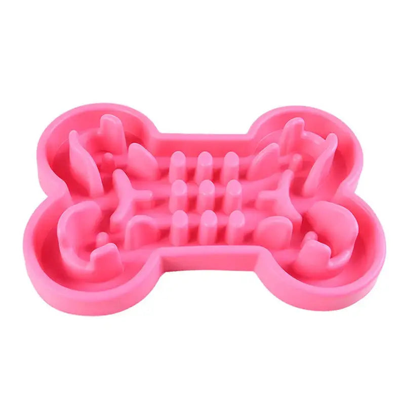 Pink silicone dog bone-shaped slow feeder bowl with raised ridges inside.