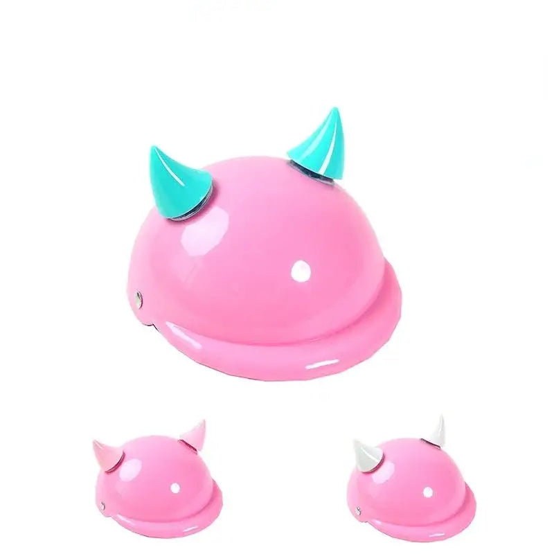 Pink rounded object with teal horns resembling a cute monster or creature.