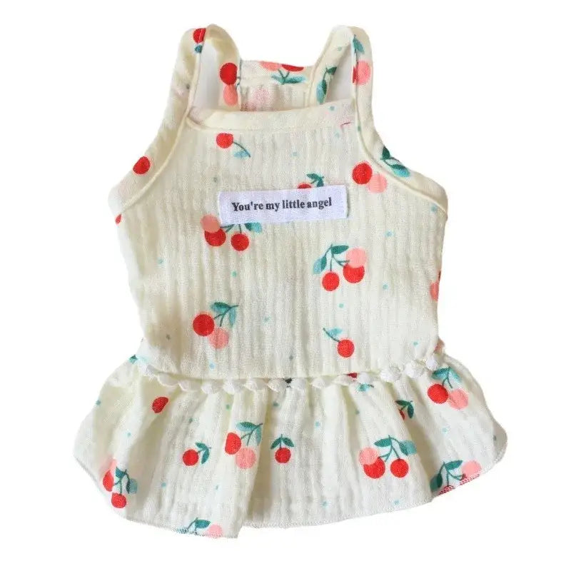 Sleeveless white baby dress with a cherry print pattern and a ruffled bottom.