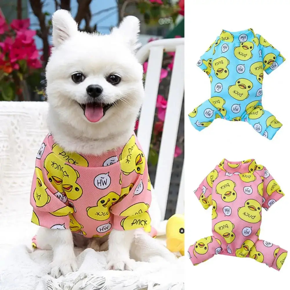 Fluffy white dog wearing a pink pajama outfit with yellow duck prints.